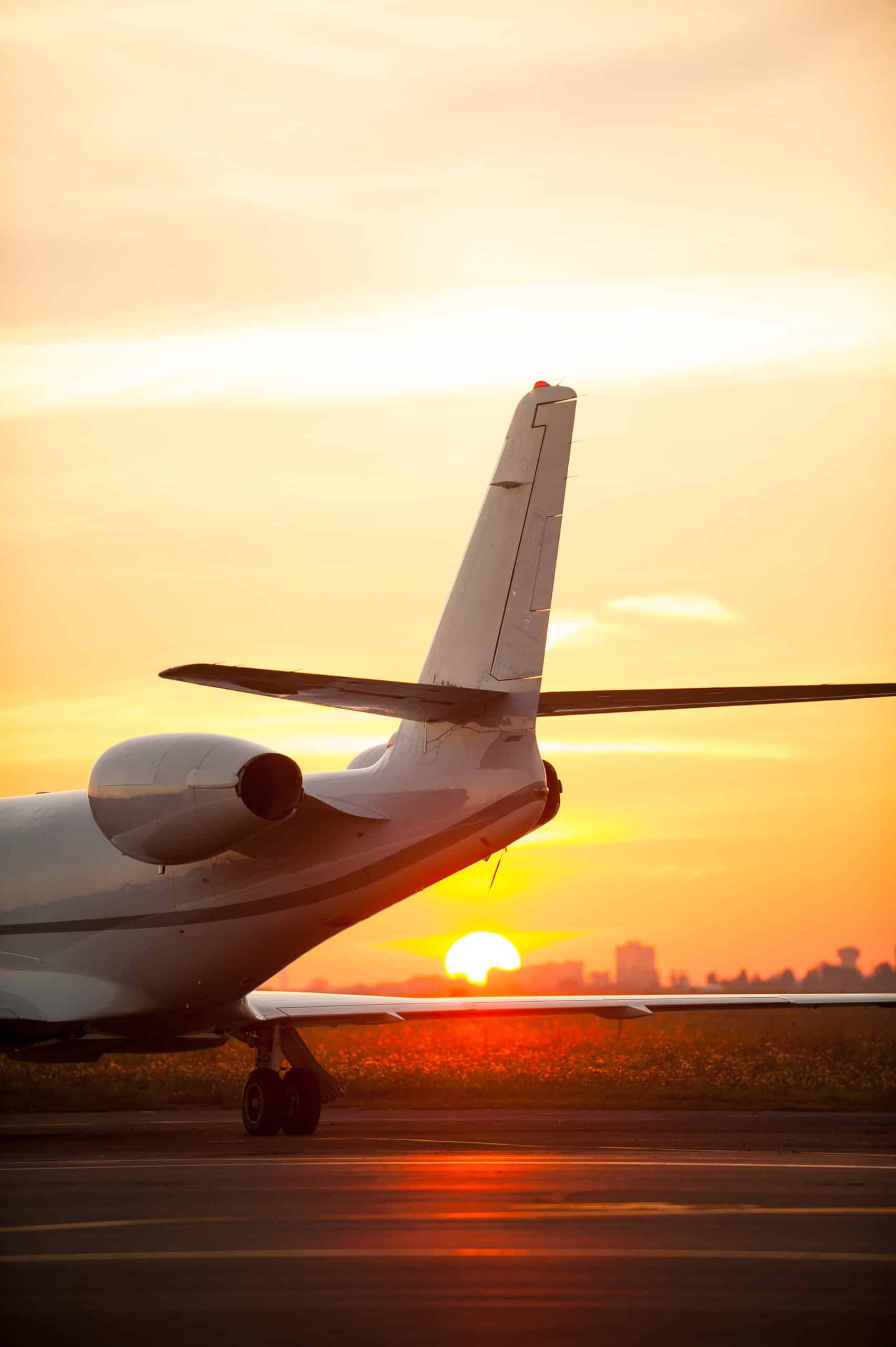 Just arrived. Cropped image of airplane landing in airport with sunset in the background