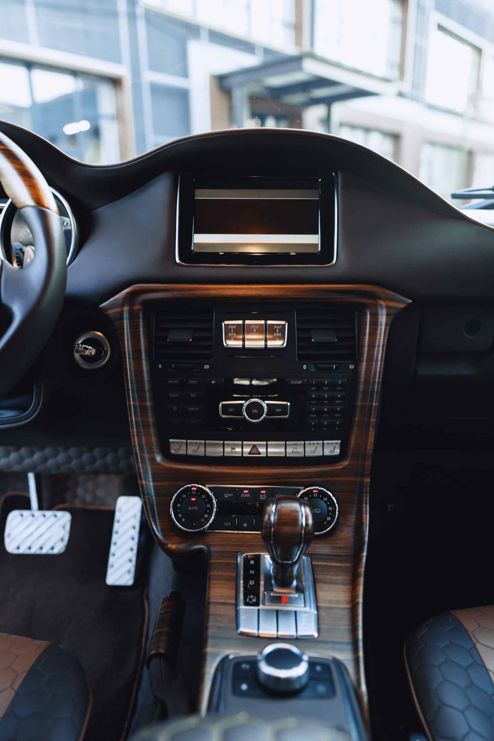 Elegant car interior showcasing advanced controls and premium materials during daylight.